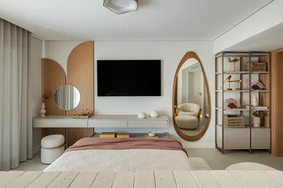 Quarto com painel de TV em madeira, espelho oval e estante decorativa — reforma apartamento Baixada Santista