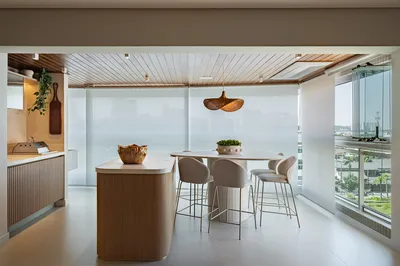 Varanda gourmet com bancada alta e banquetas com vista para cidade — reforma residencial