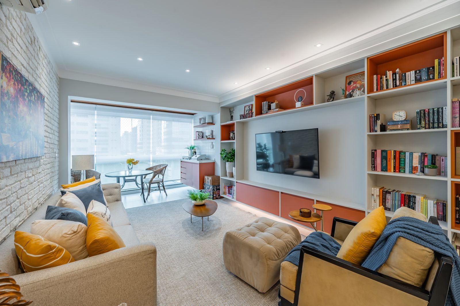 Sala de estar com parede de tijolinho branco e estante